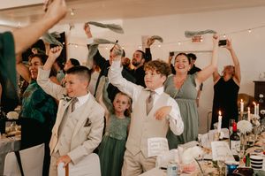 Wedding guests raise their glasses in celebration during a reception at an elegant indoor venue.