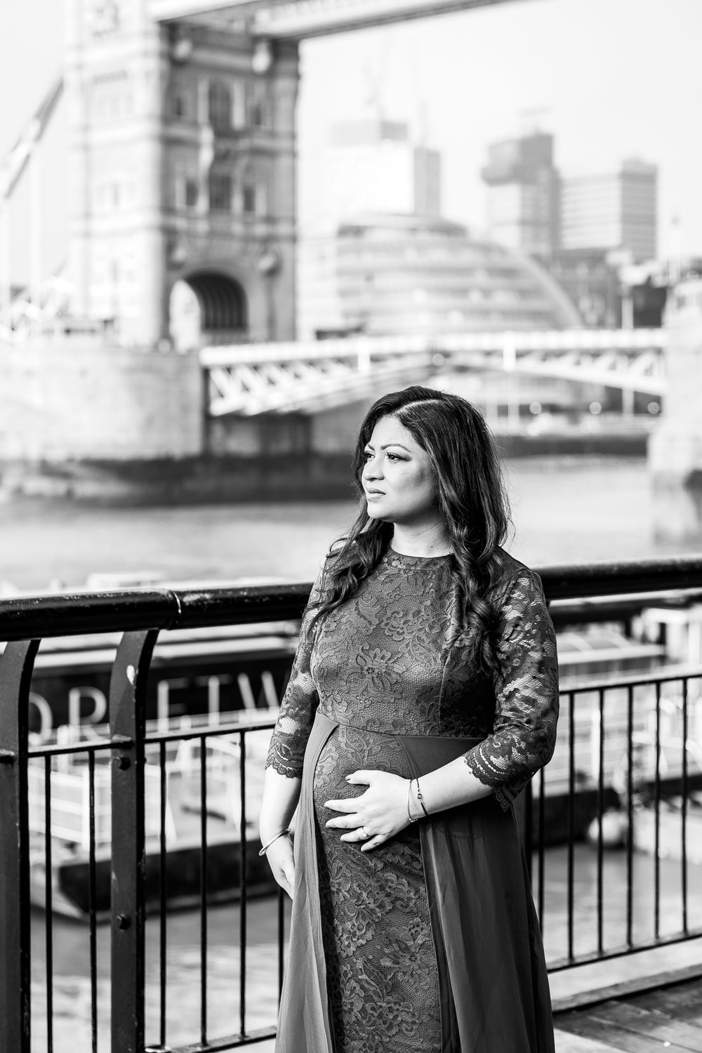 pregnant woman looking out to river thames in london
