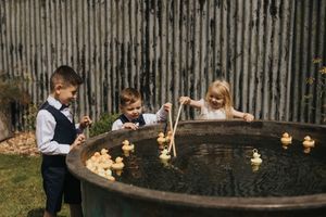A series of photos showing people at a wedding reception gathering around a wooden barrel outdoors at dusk.