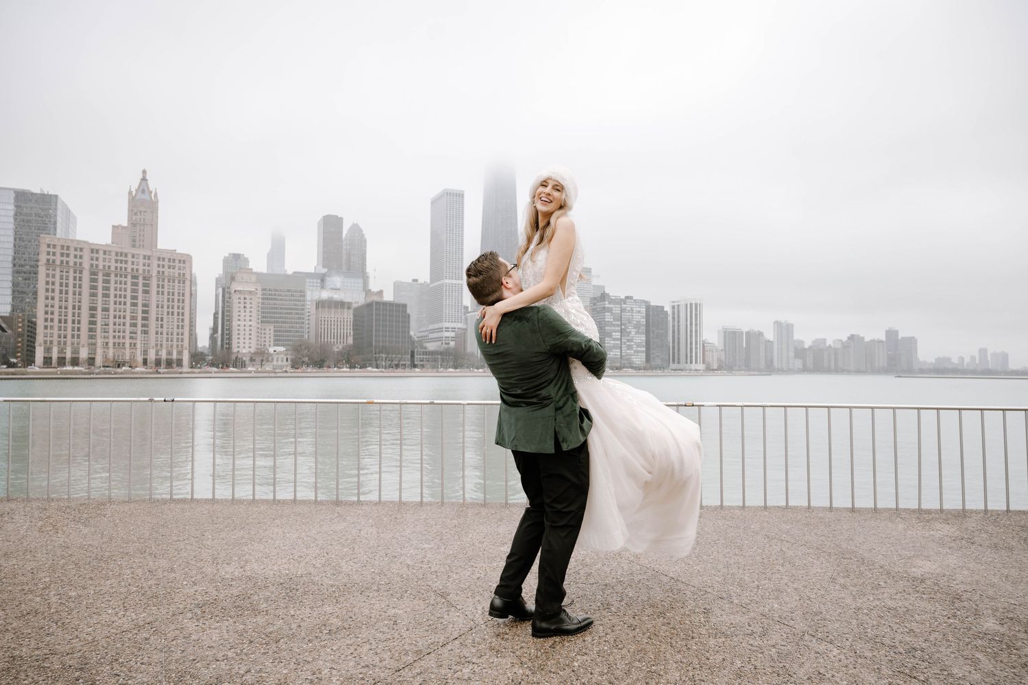 A couple takes dramatic wedding photos against the Chicago skyline on a misty winter morning by Lake Michigan.