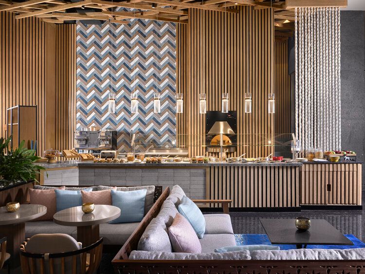 Modern restaurant interior with wood paneling, geometric patterns, and contemporary dining furniture in warm earth tones.