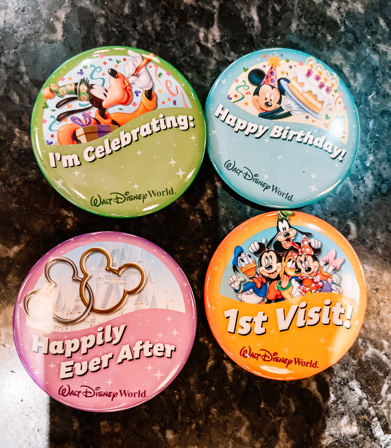 Four Disney World celebration buttons featuring classic characters and special occasion messages.