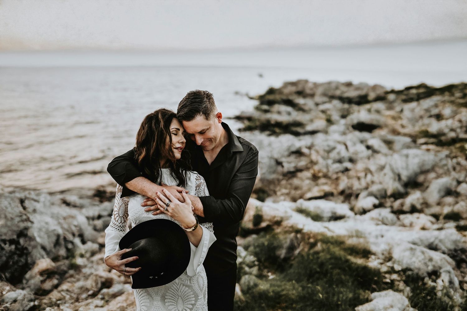 romantic moody portrait of a couple embracing each other and intimately leaning their heads together
