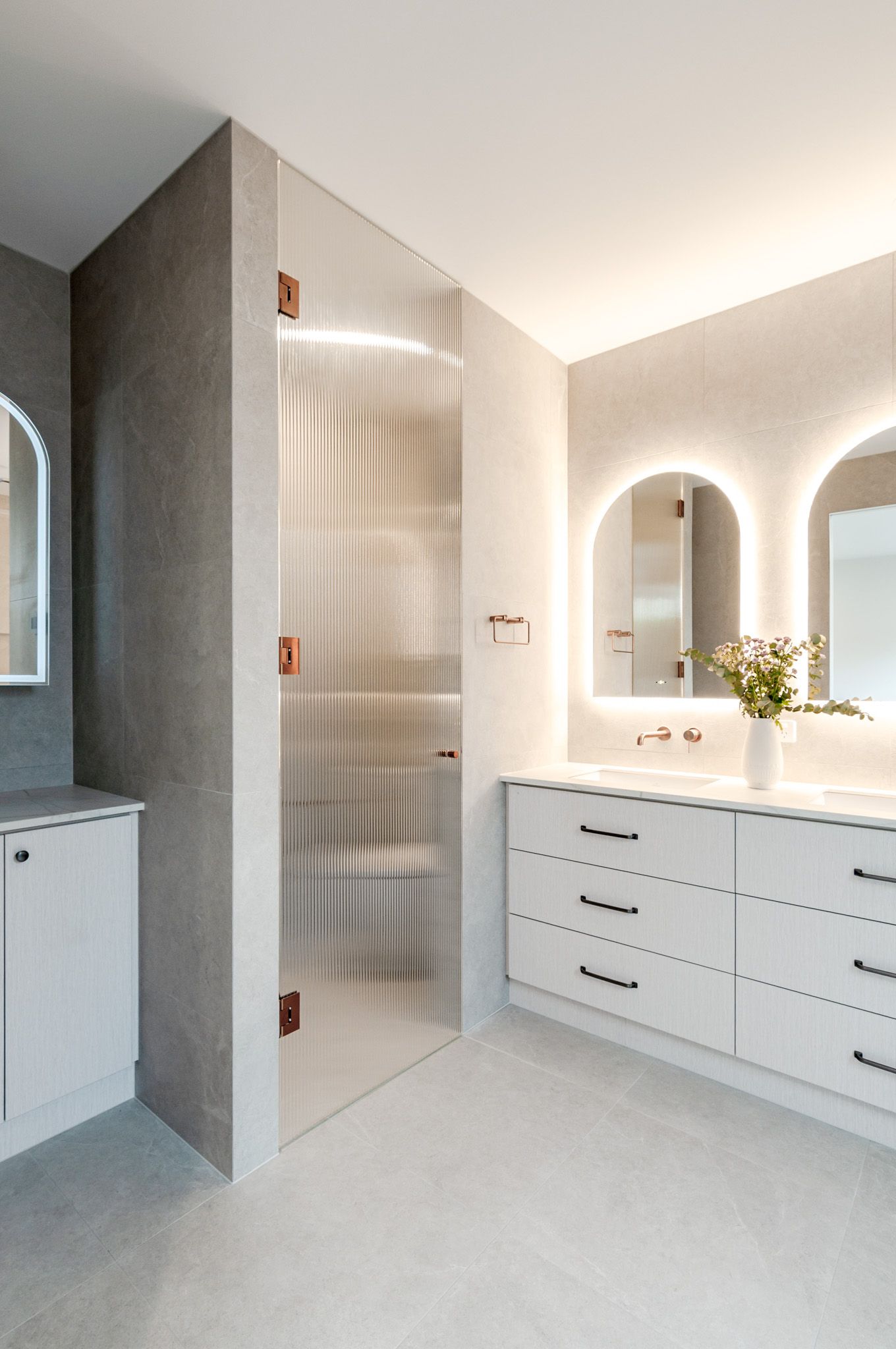 Modern minimalist attic space features curved white walls, built-in storage cabinets, and soft ambient lighting creating an elegant flow.