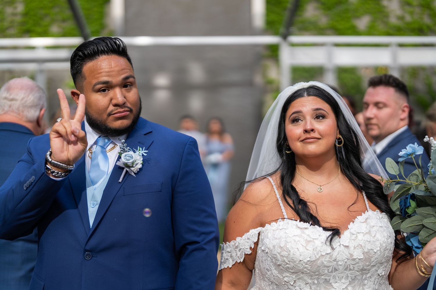 Romantic outdoor wedding celebration shows couple in traditional wedding attire dancing together on garden patio.