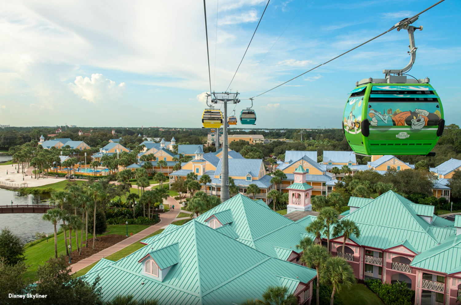 Aerial view of Disney Skyliner gondolas traveling over Caribbean-style resort buildings.
