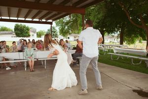 An outdoor wedding dance floor with string lights and paper lanterns creating a romantic evening atmosphere.