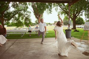 Candid motion shots of a bride and groom swinging together at a park during their wedding photoshoot.