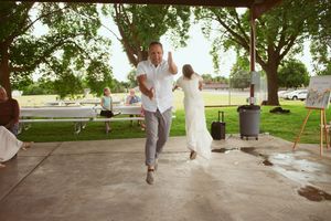 Energetic dancing and celebration taking place under a covered outdoor pavilion.