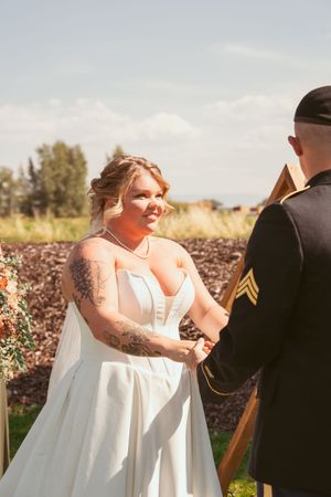 Joyful wedding celebration with dancers in formal attire on an outdoor grassy venue.