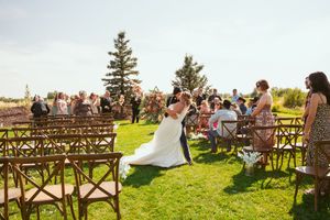 Wedding guests seated on wooden benches at an outdoor ceremony with mountain views.