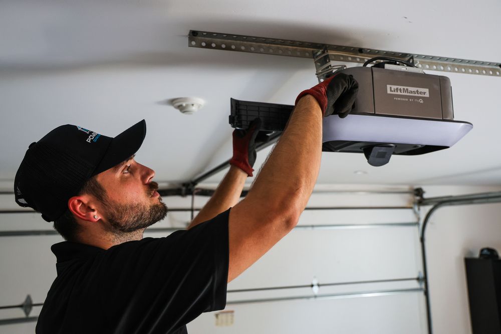 Technician installing or repairing garage door opener system.