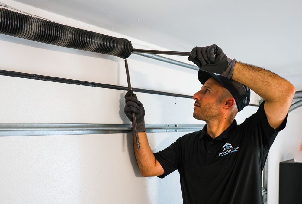 Close-up of garage door maintenance work being performed on track system.