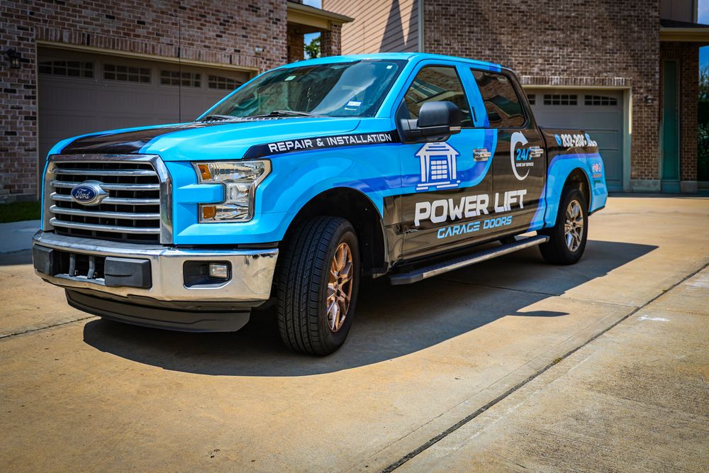 Fleet of blue branded service trucks parked outside a commercial building.