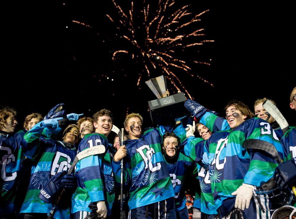 Hockey team celebrates championship win under fireworks display.