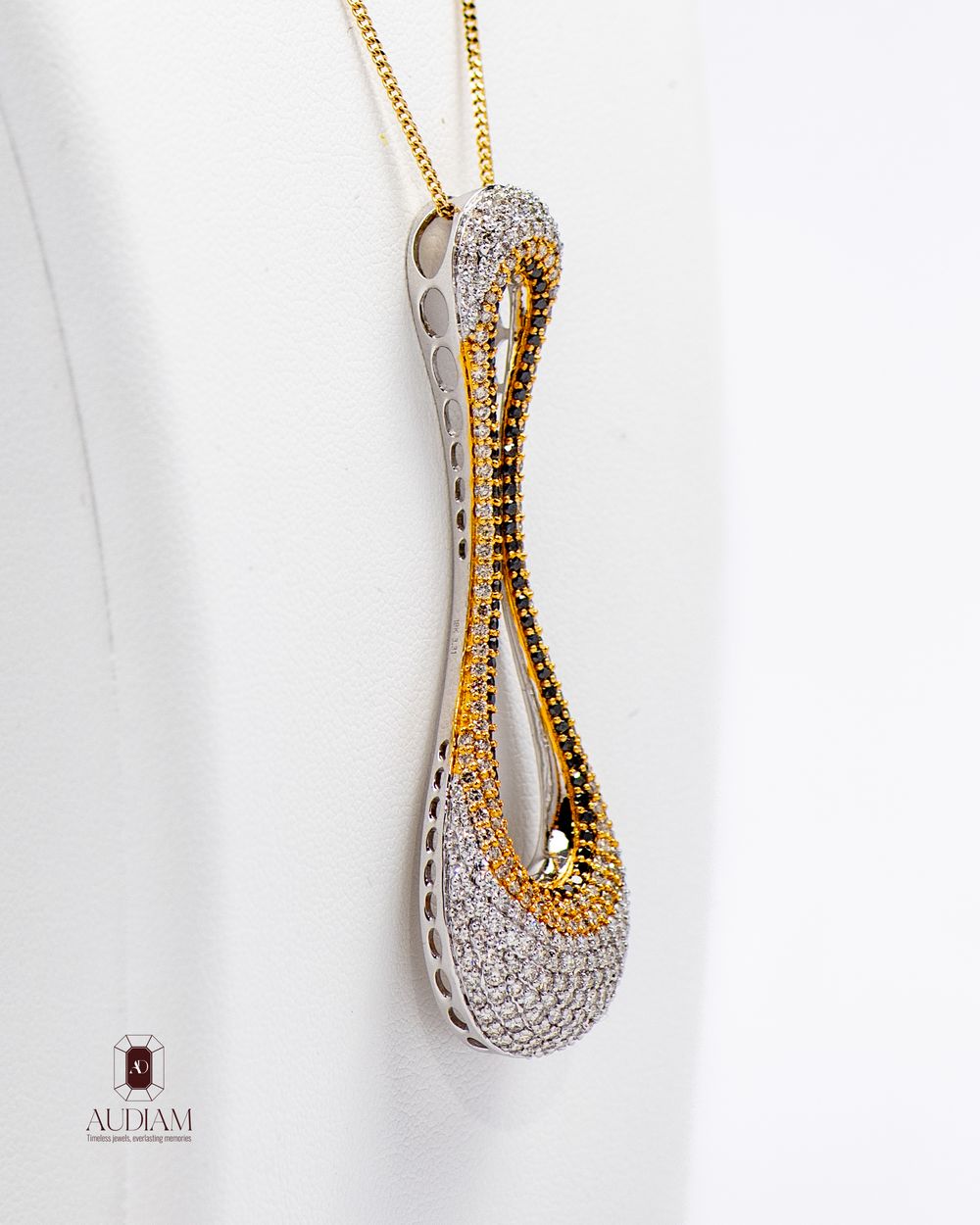 Designer pendant showcasing twisted gold and diamond pavé design in modern sculptural style.