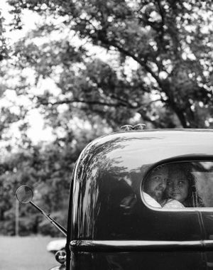 A couple posing inside a vintage truck.