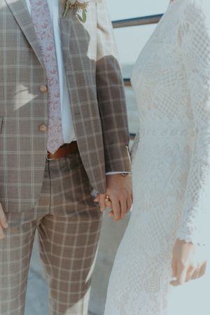 A detail shot of a bride and grooms outfits.