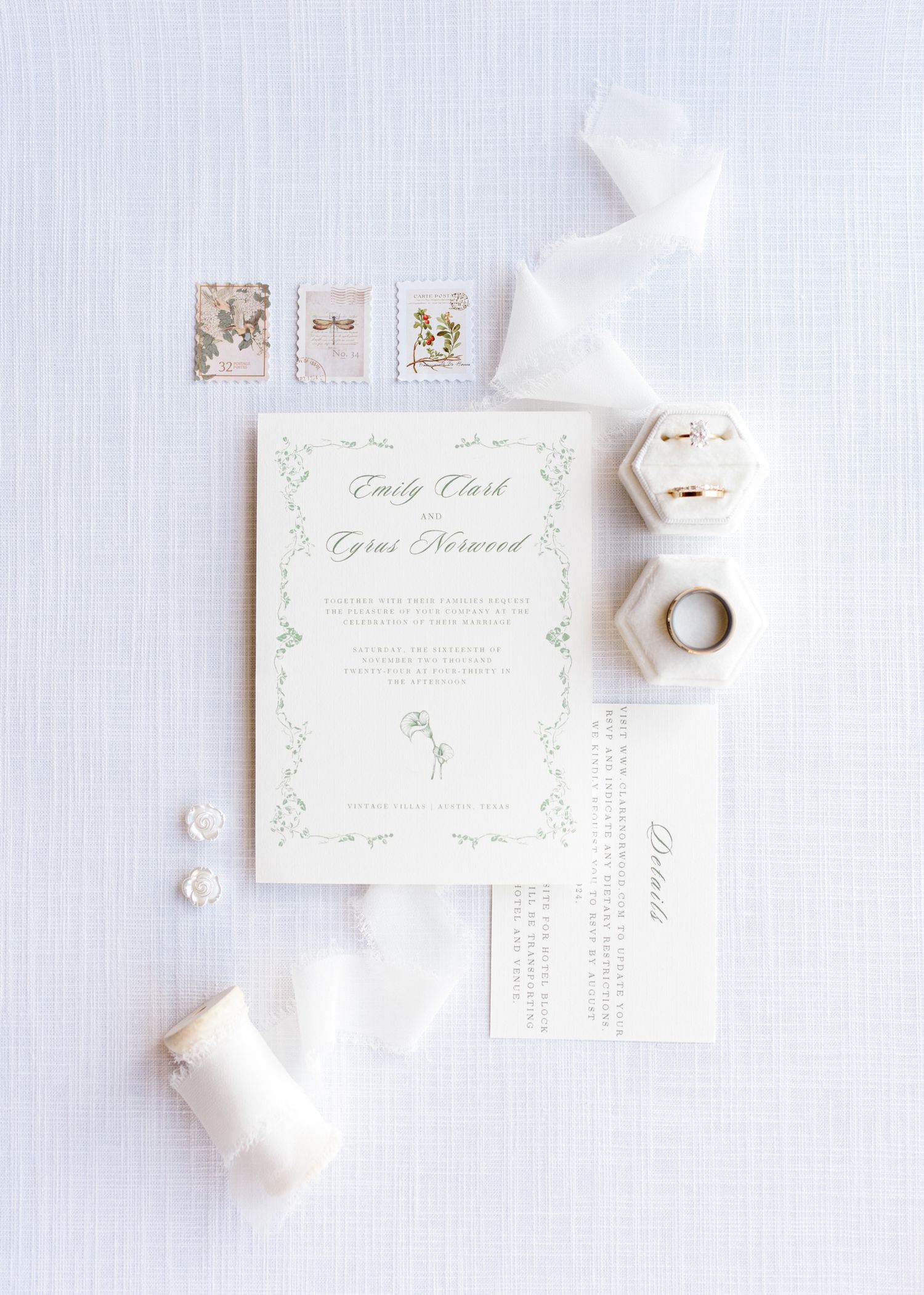 Elegant wedding invitation suite with delicate floral design and white ribbon details.