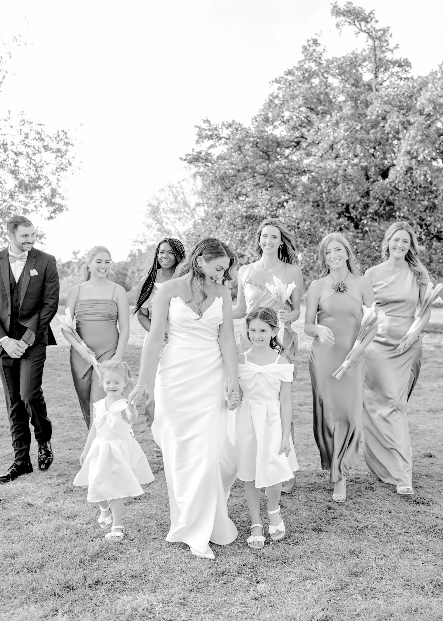 Black and white photo of wedding party walking together outdoors.