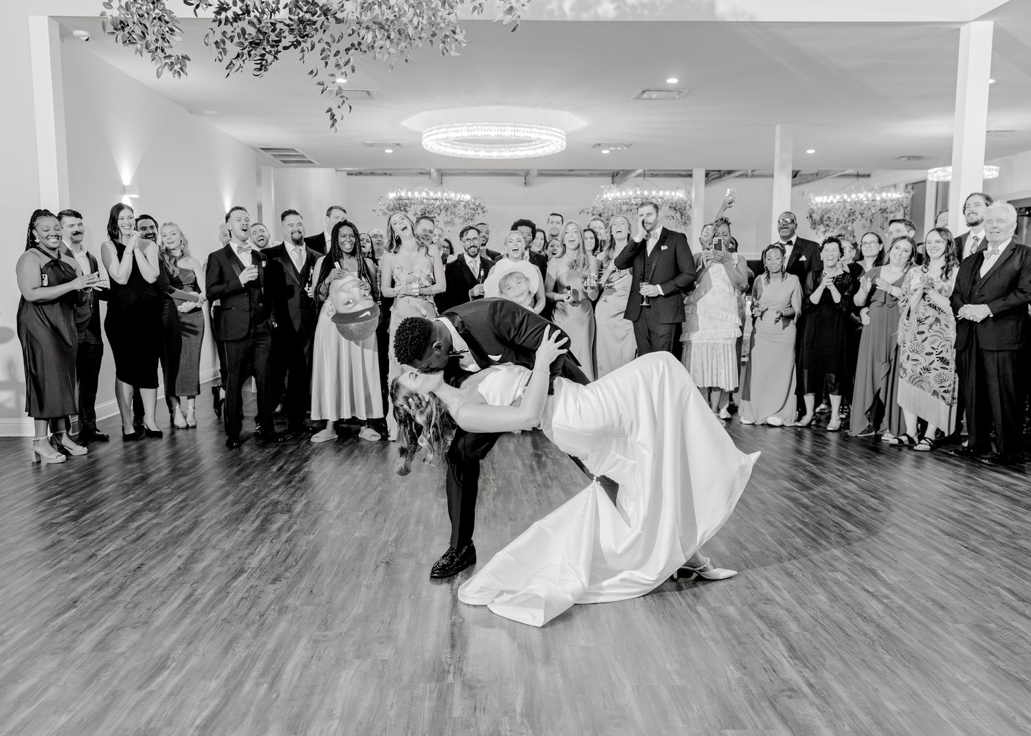 Wedding couple performs dramatic dance dip during their first dance at reception.