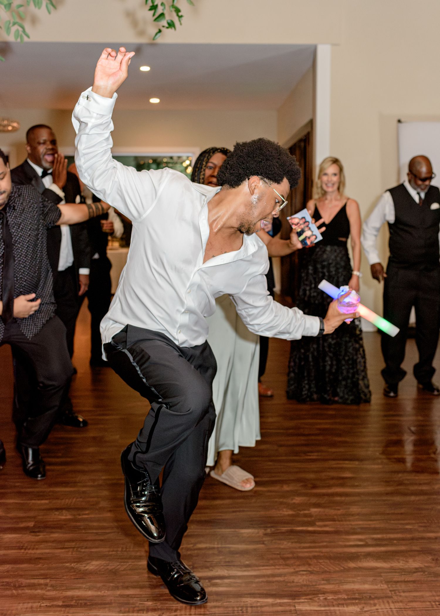 Guest showing off impressive dance moves on wooden floor during wedding reception celebrations.