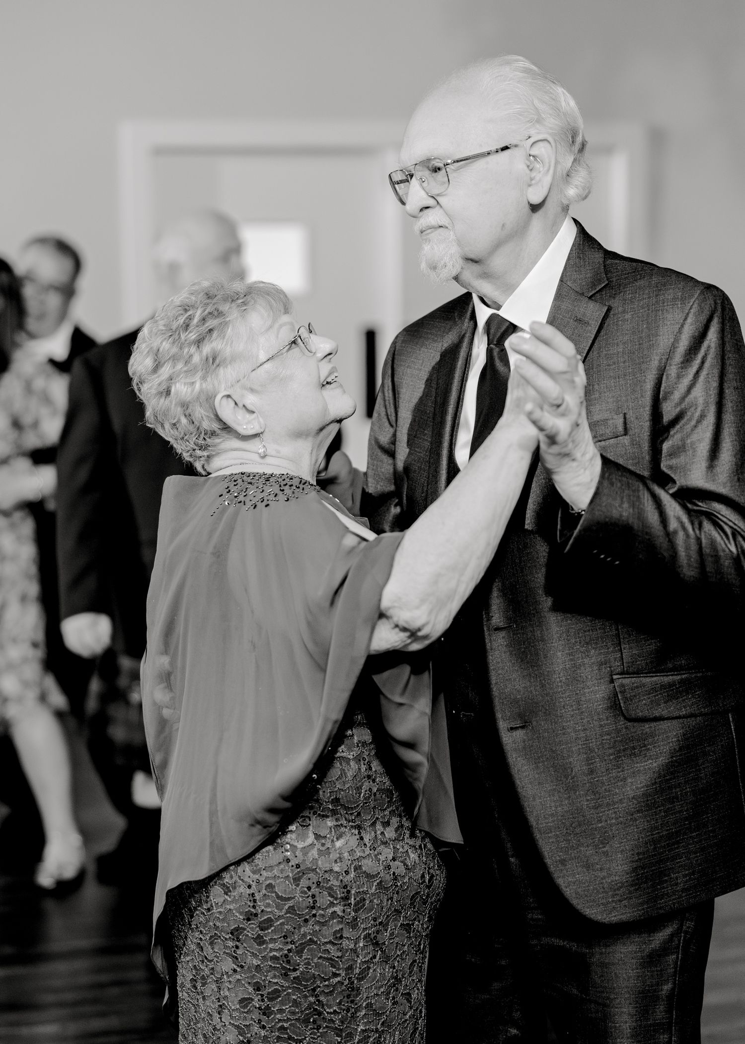 Elegant couple sharing a romantic slow dance in formal attire.