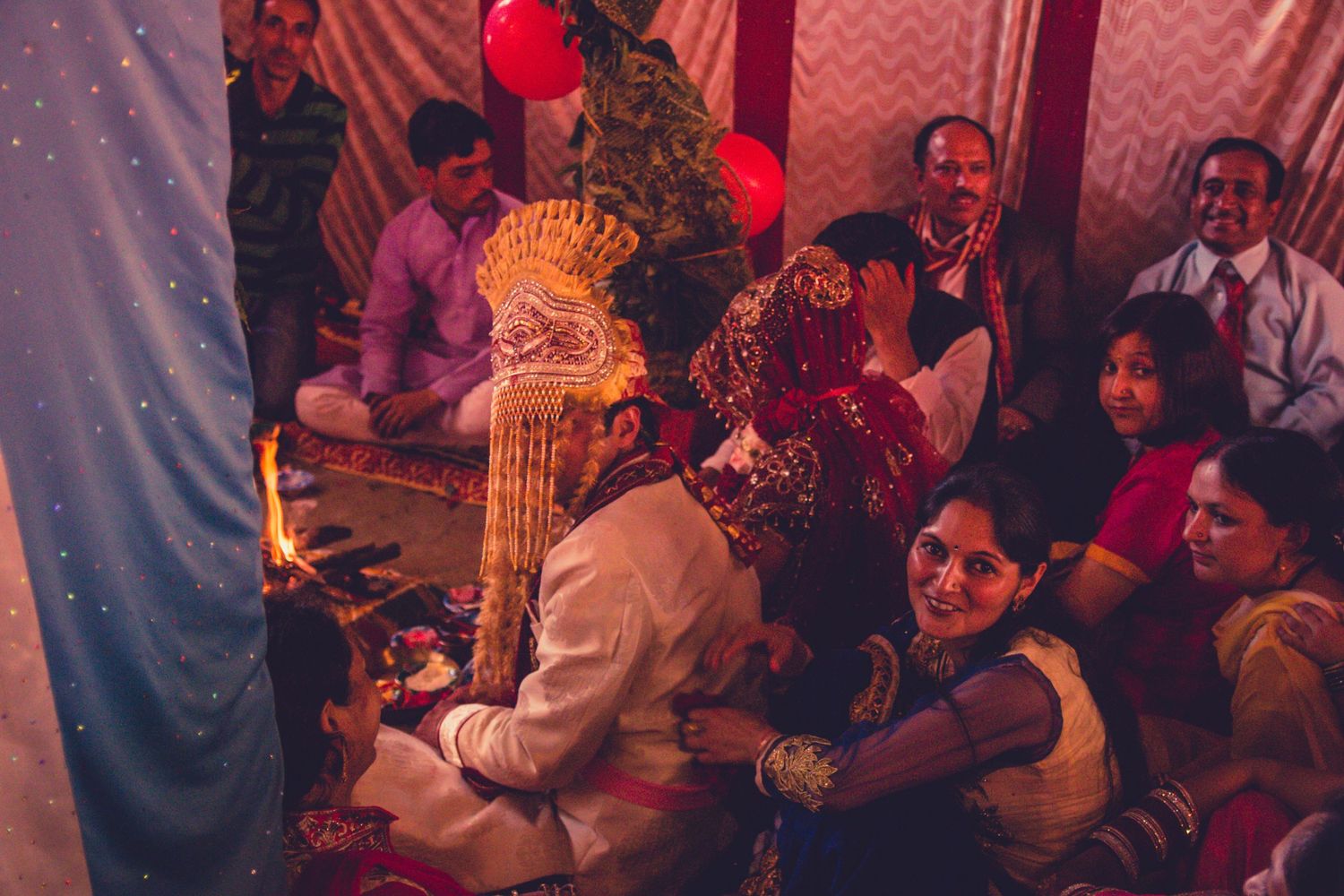 Colorful Indian wedding celebration with traditional decorations and gathered guests.