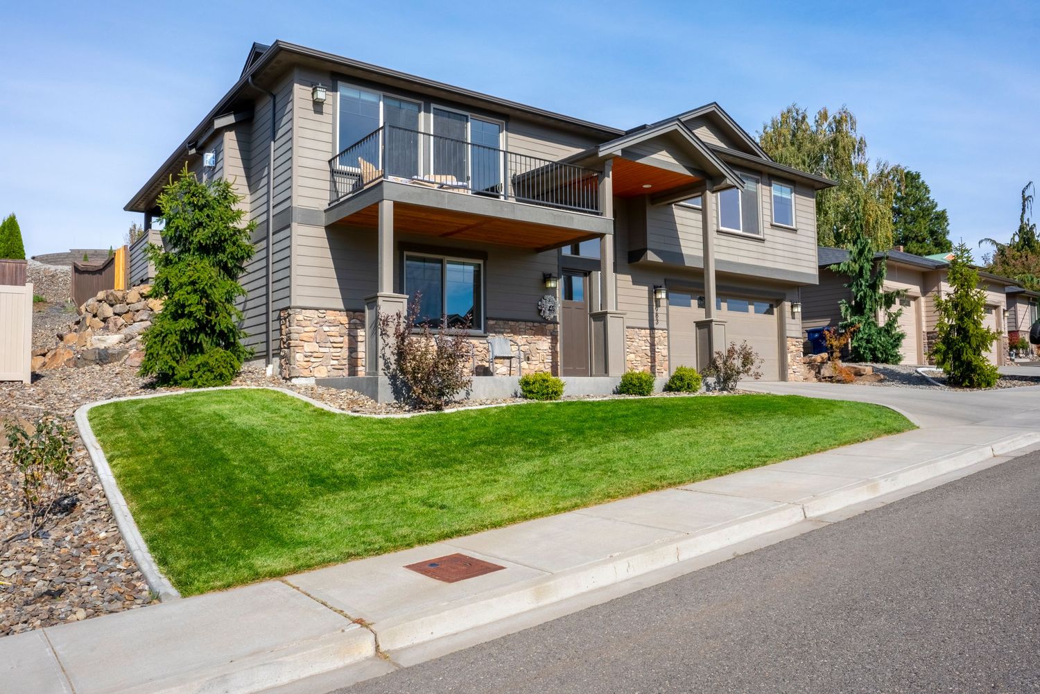 Luxury home exterior with landscaped yard and modern architecture in Wenatchee, WA real estate listing.