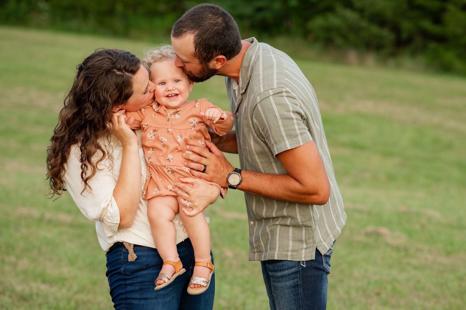 Happy family sharing playful moment together outdoors in green field.