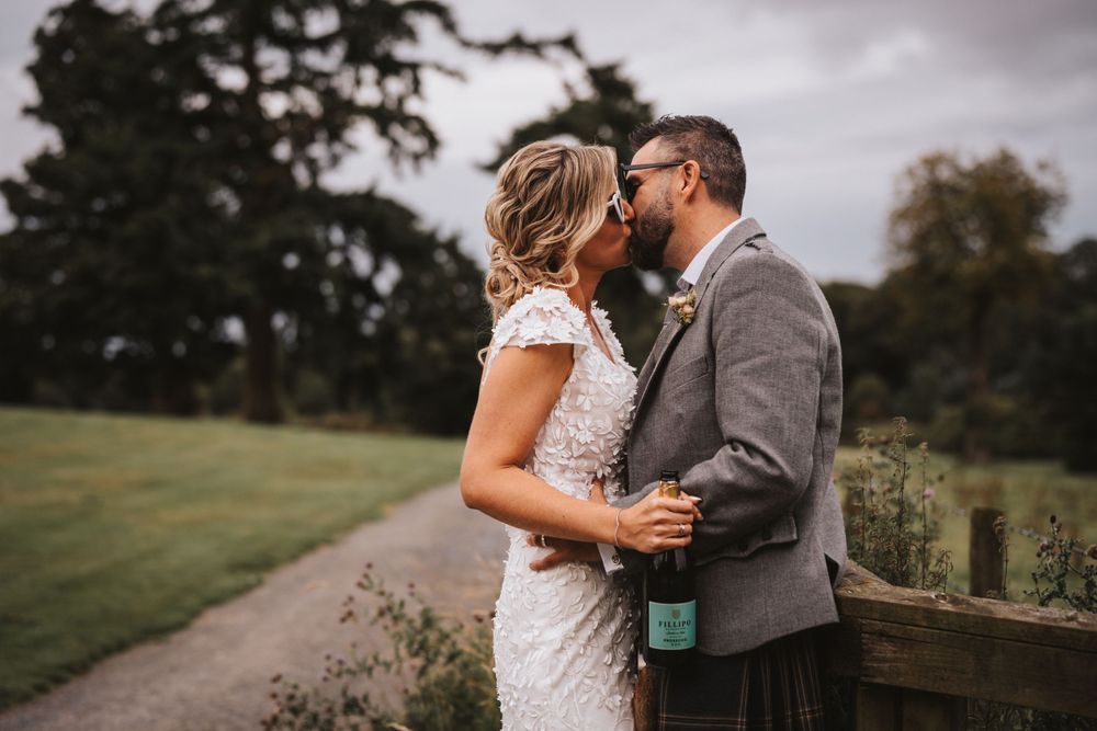 Intimate moment between newlyweds on their wedding day in a rustic outdoor setting at Meldrum House Hotel Aberdeenshire.