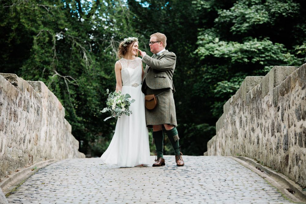 a candid shot of the bride and groom on a bridge in Old Aberdeen