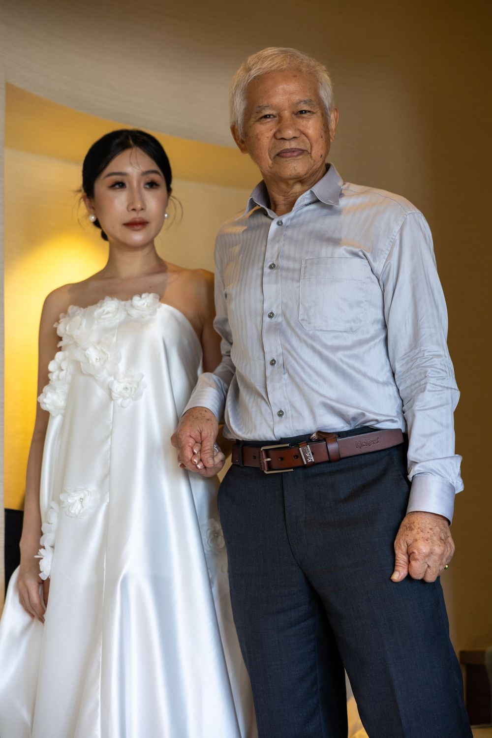Two people stand together in formal attire during a wedding photoshoot.