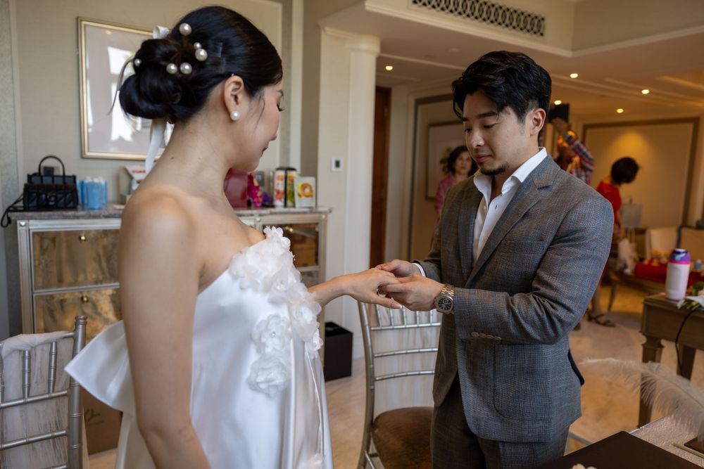 Couple sharing an intimate moment during a wedding ceremony in an elegant indoor setting.