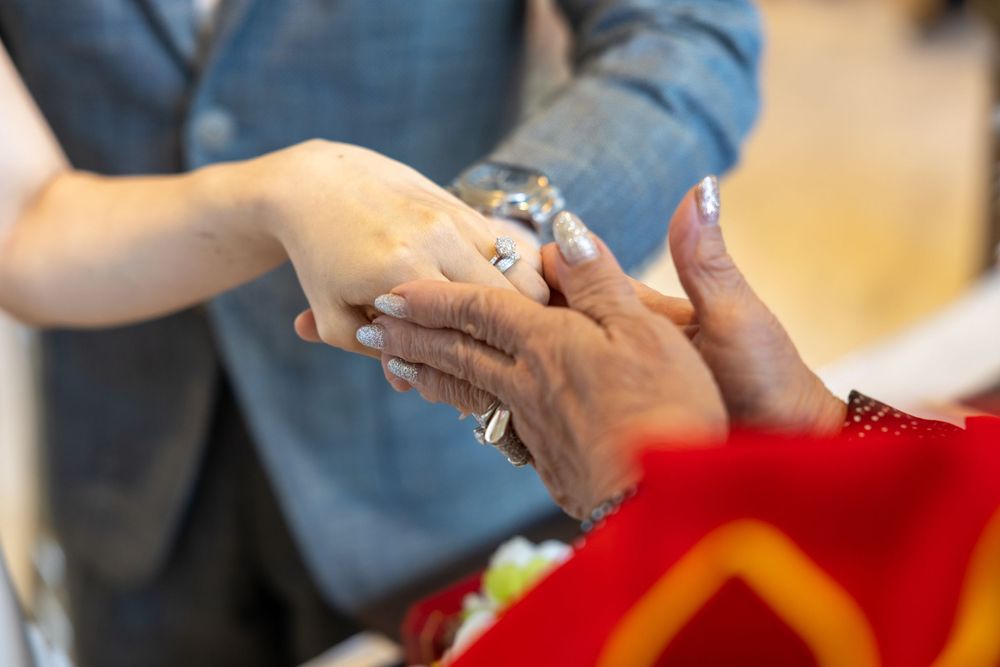 Close-up shot of hands exchanging rings during a wedding ceremony.