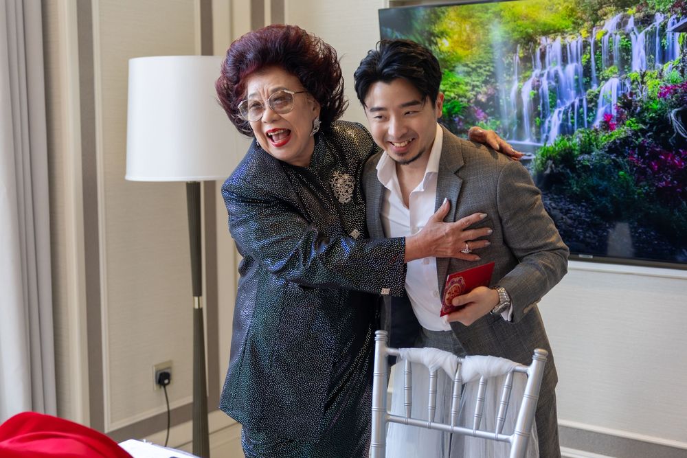 A celebratory moment shared between two people at an indoor event with artwork visible.