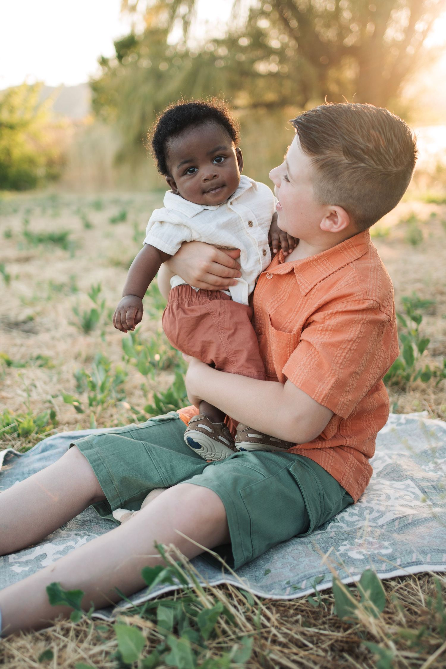 A boy holds is brand new baby brother for a photo