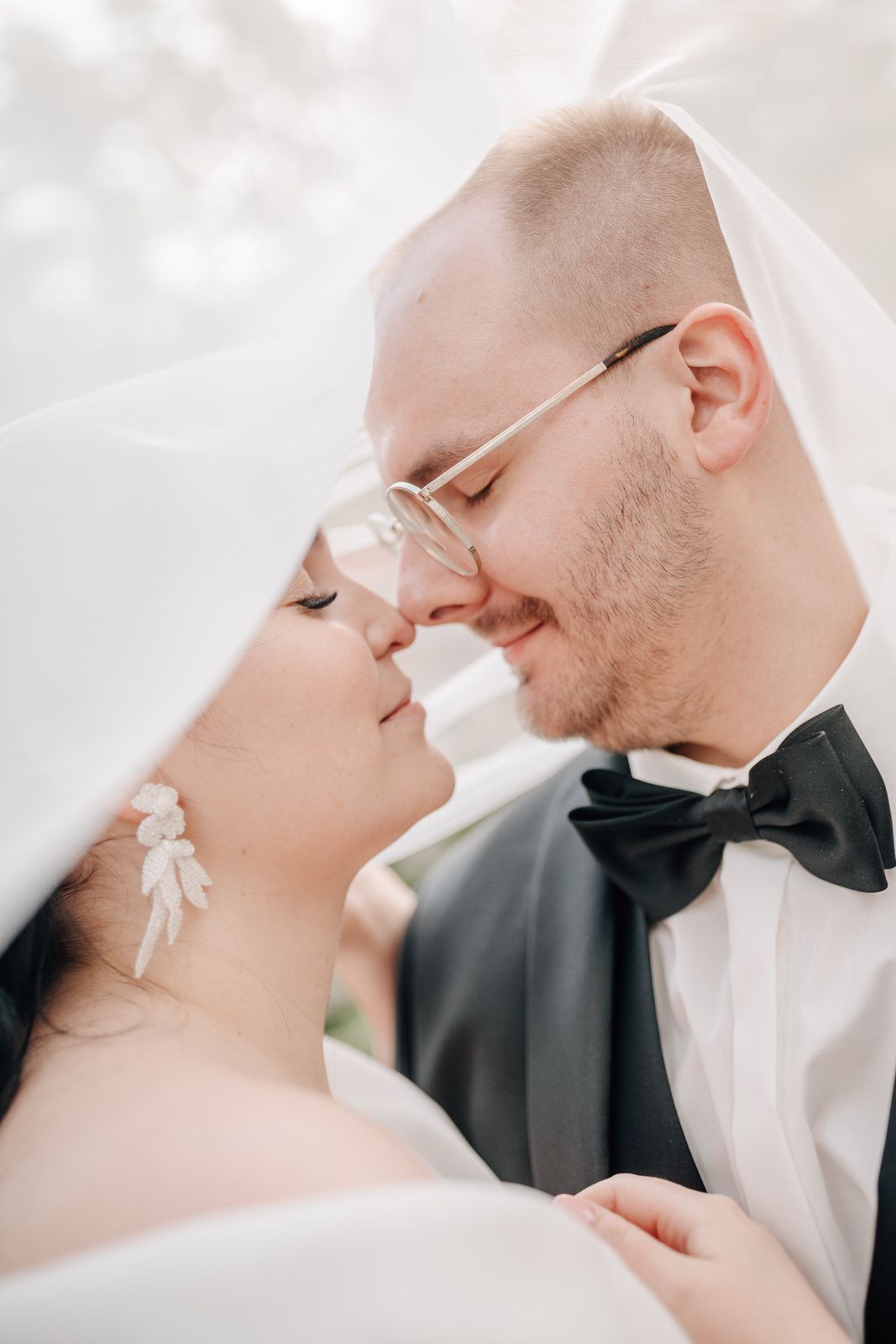A couple sits together in a vintage red and white classic car on their wedding day. Hochzeit La Vette ortenberg