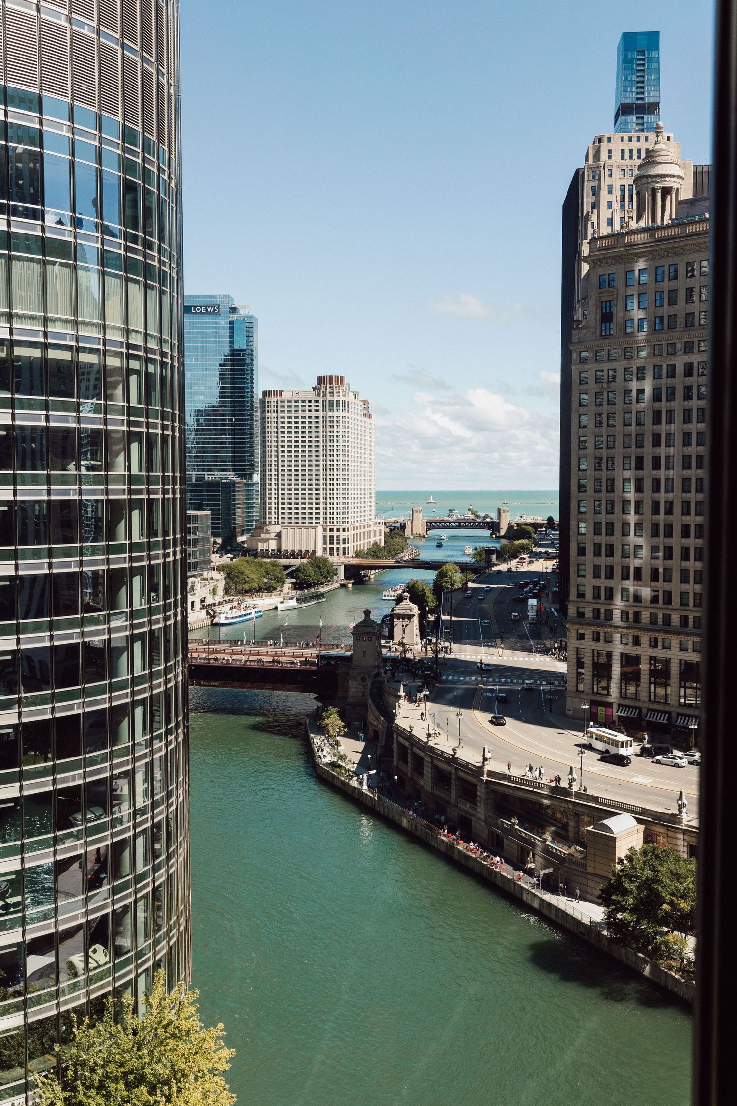 Panoramic view of Chicago River and downtown buildings on a sunny day.