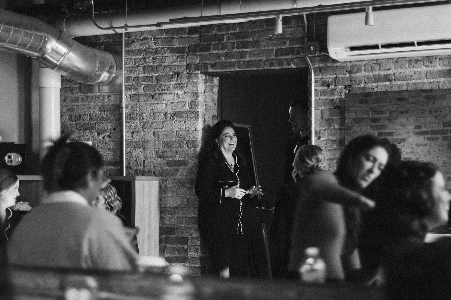 Black and white interior shots of exposed brick venue with industrial lighting.
