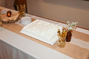 White lace table runner with decorative elements and floral arrangements on a table at a formal event.