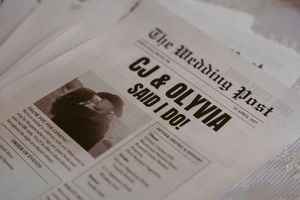 Vintage-style newspaper spread showing headlines and columns on a weathered paper surface.