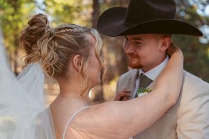 An intimate moment between newlyweds during their outdoor forest wedding ceremony.