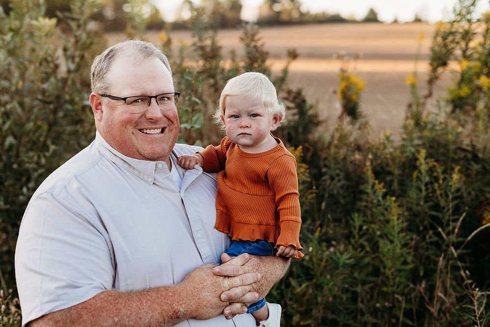 A loving scene of a parent and young child sharing a warm moment outdoors during golden hour.