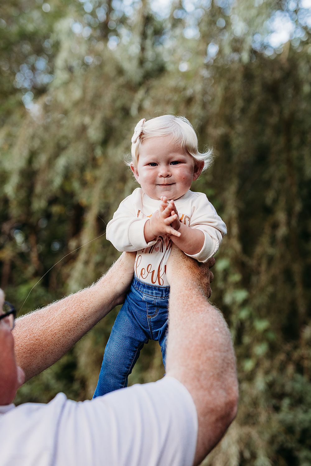 A series of photos showing a baby in overalls being lifted up against a blurred outdoor background.