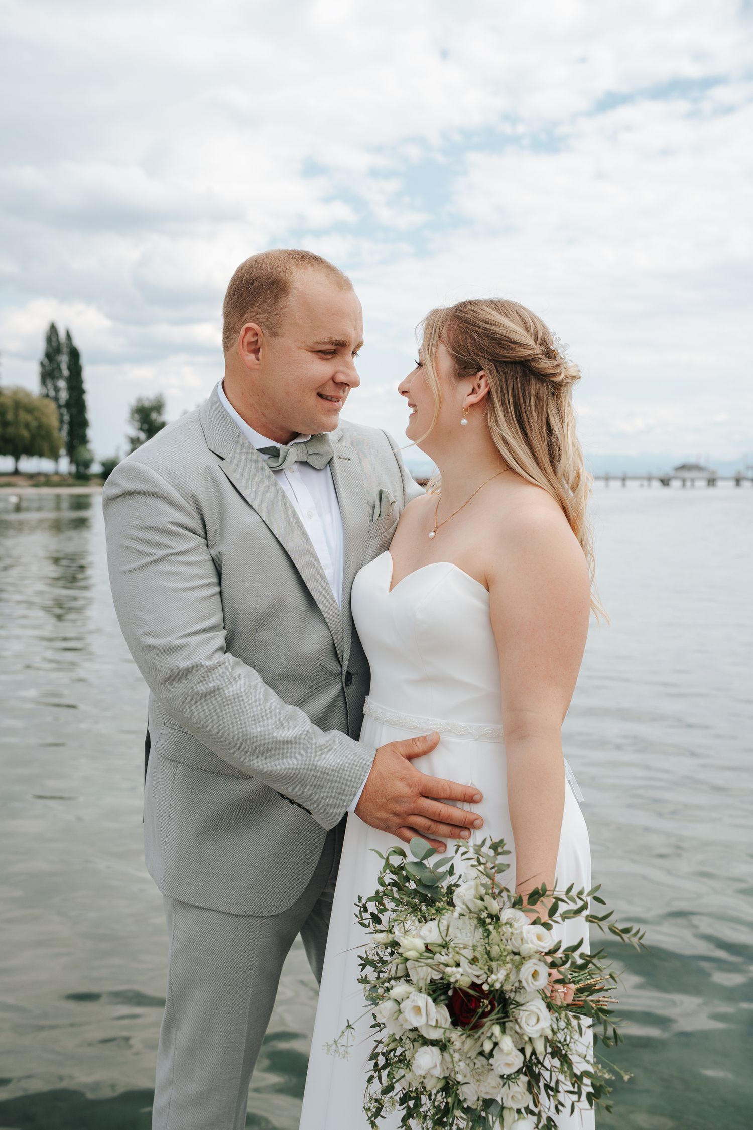 Romantic outdoor portrait in a golden wheat field under cloudy skies.