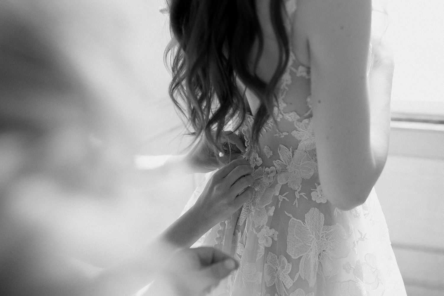 Artistic black and white detail shots of wedding dress lace and fabric.