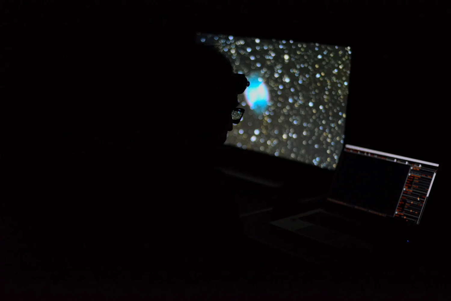 Écran d’ordinateur affichant une nébuleuse colorée dans un ciel étoilé, utilisé pour l’observation astronomique nocturne.