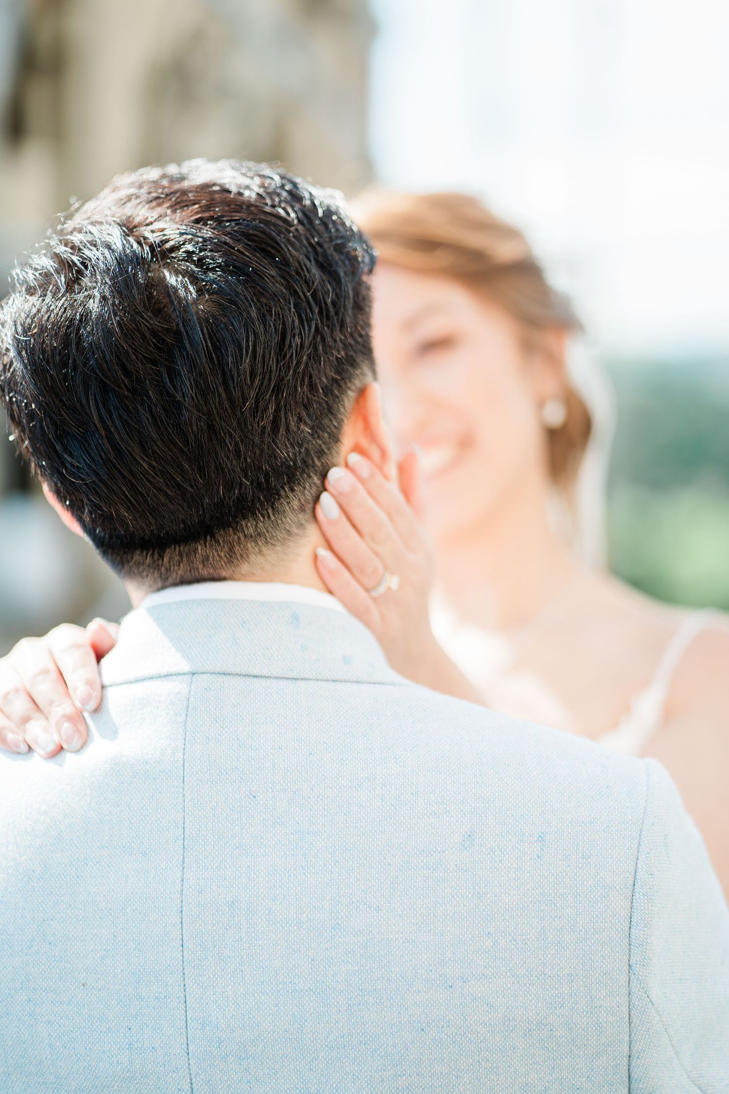 Bride smiling at groom with a shining diamond ring in the foreground at Wollaton Hall
