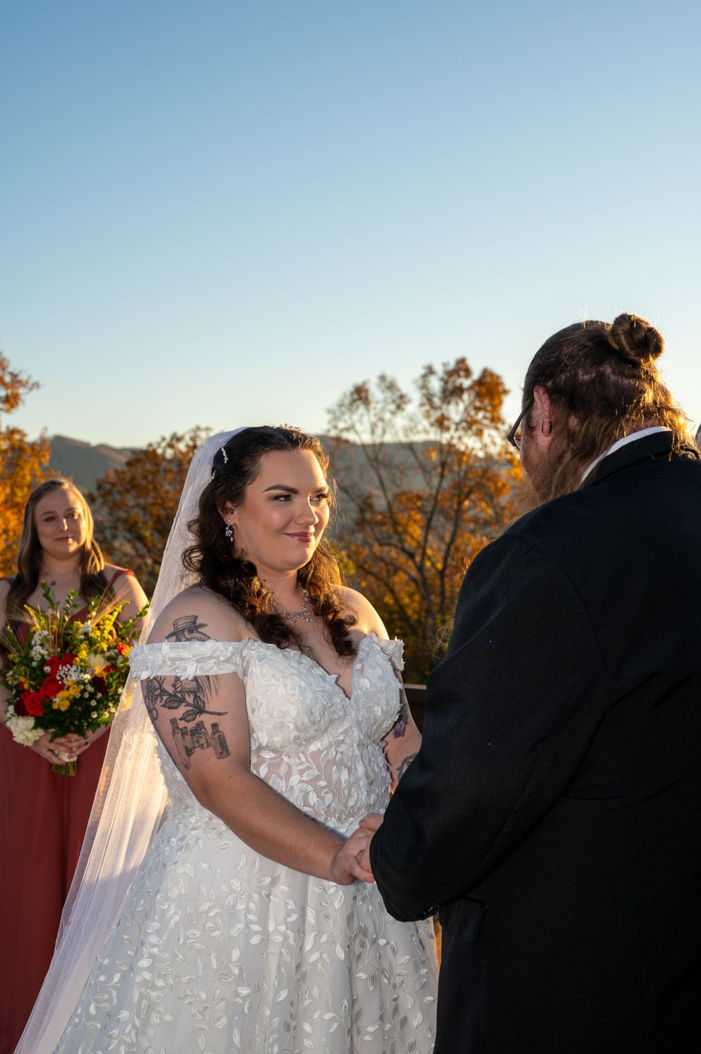 Wedding ceremony on mountain deck with autumn scenery in background.